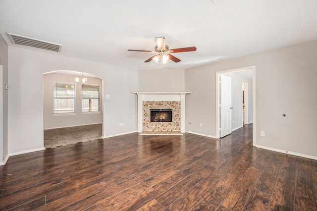 unfurnished living room with dark wood-type flooring, ceiling fan, and a fireplace