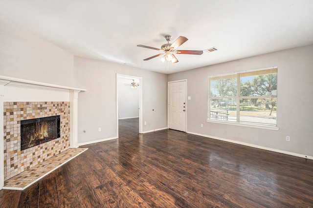 unfurnished living room featuring dark hardwood / wood-style floors, a fireplace, and ceiling fan