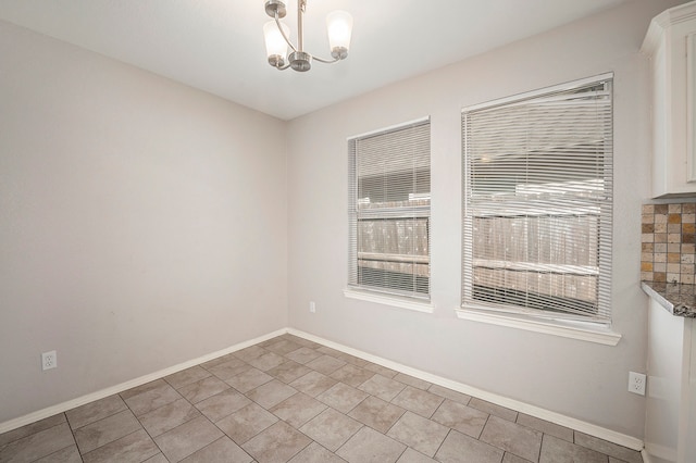 unfurnished room with a chandelier