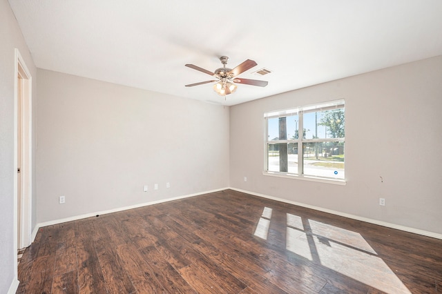 spare room featuring dark wood-type flooring and ceiling fan