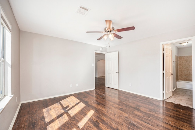 unfurnished bedroom featuring ceiling fan, dark hardwood / wood-style flooring, and ensuite bath