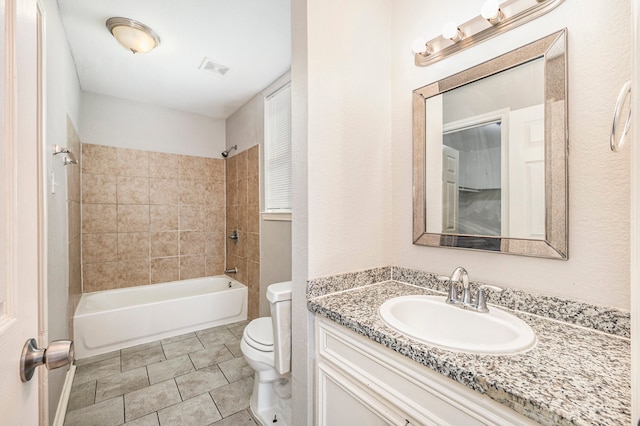 full bathroom featuring vanity, tiled shower / bath combo, toilet, and tile patterned flooring