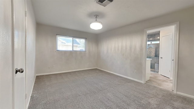 unfurnished room featuring light carpet