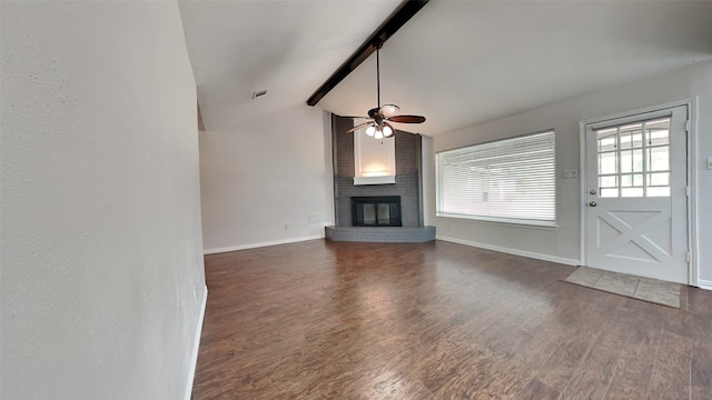 unfurnished living room featuring lofted ceiling with beams, a fireplace, plenty of natural light, and dark hardwood / wood-style floors