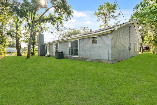 back of house with central AC and a yard