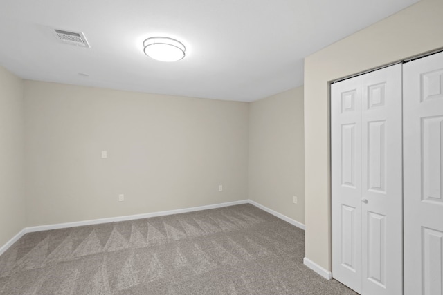 unfurnished bedroom with light carpet and a closet