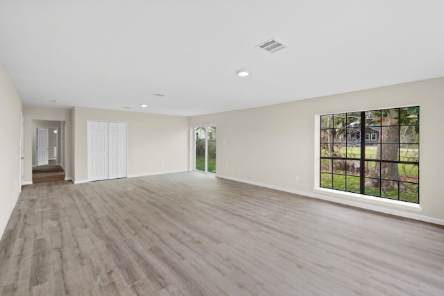 unfurnished living room with a wealth of natural light and light hardwood / wood-style flooring