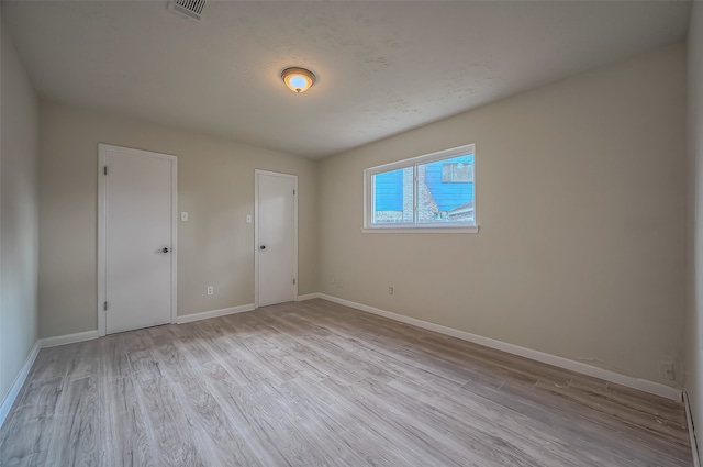 spare room featuring light wood-type flooring