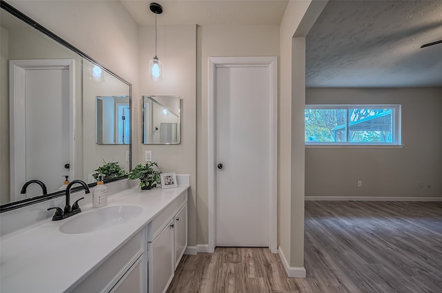 bathroom with vanity, a textured ceiling, and wood-type flooring