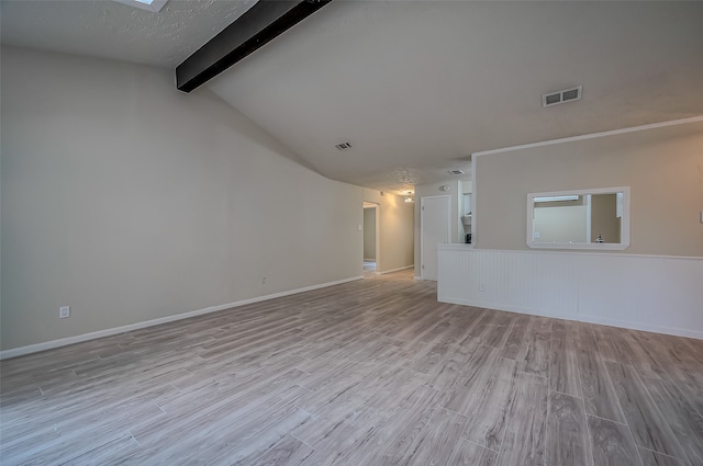 unfurnished living room featuring light hardwood / wood-style flooring and vaulted ceiling with beams