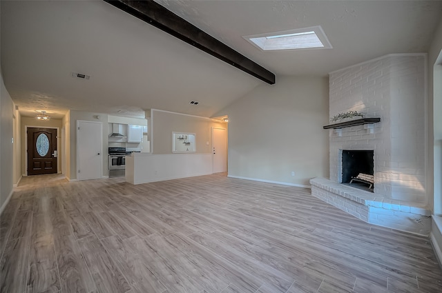 unfurnished living room featuring lofted ceiling with skylight, light hardwood / wood-style flooring, and a fireplace