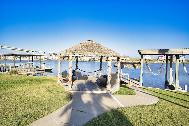 view of dock featuring a yard, a gazebo, boat lift, and a water view