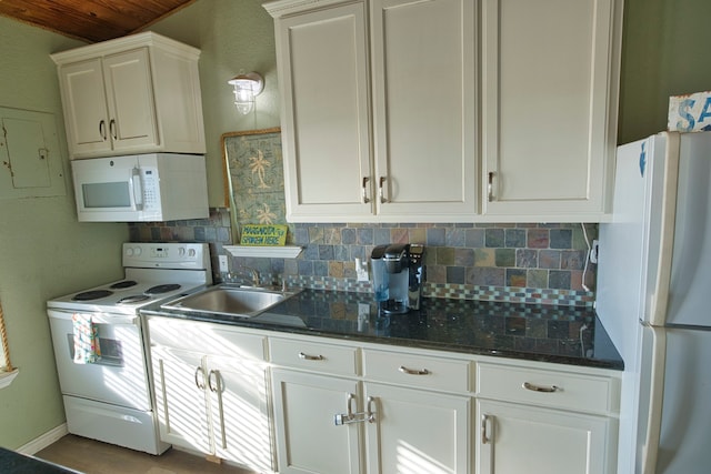 kitchen with white cabinets, tasteful backsplash, dark stone counters, sink, and white appliances