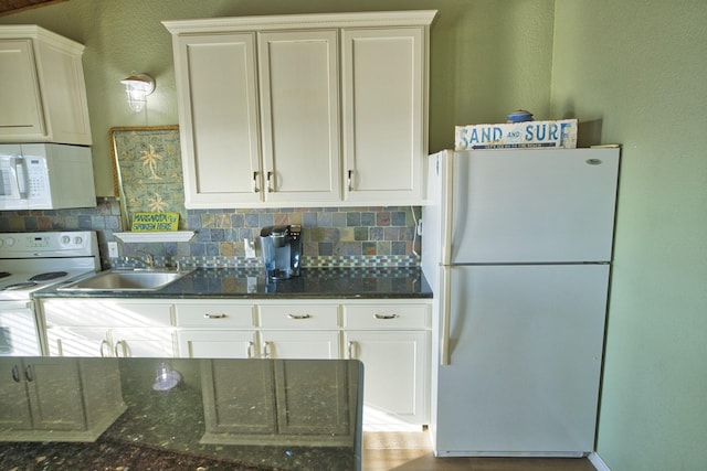 kitchen featuring white cabinetry, tasteful backsplash, white appliances, and a sink