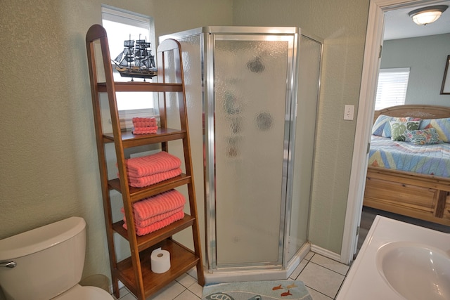 bathroom with tile patterned floors, toilet, and walk in shower