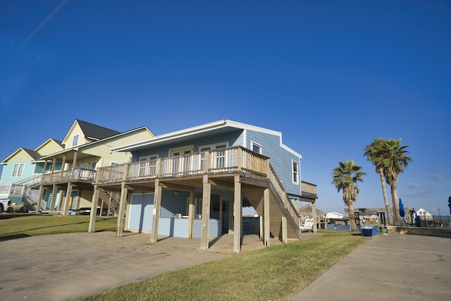 exterior space featuring a lawn, a deck, and stairs