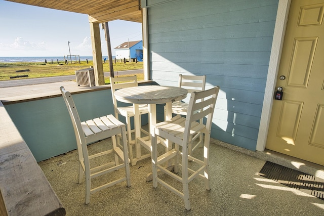 balcony with outdoor dining area and a water view