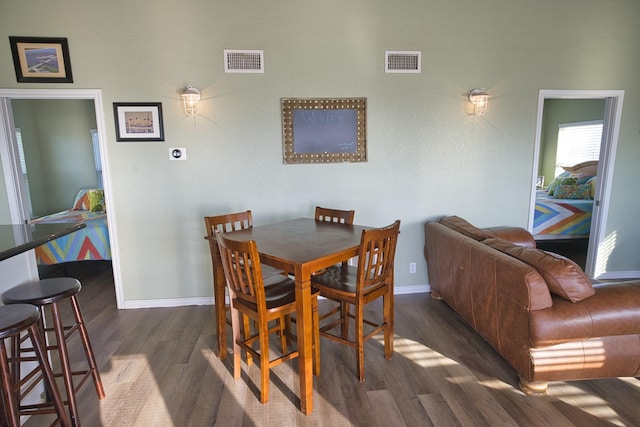 dining area with visible vents, dark wood-style floors, and baseboards