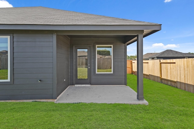 property entrance with a lawn and a patio area