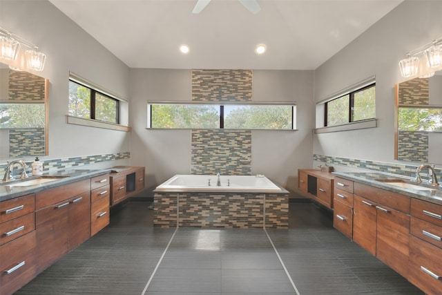 bathroom featuring vanity, plenty of natural light, and tiled tub