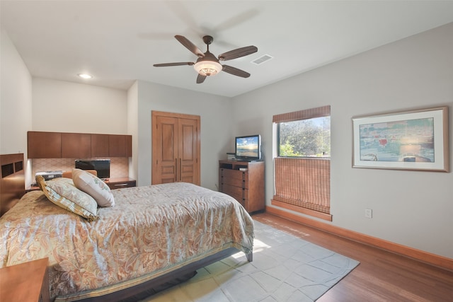 bedroom with a closet, light wood-type flooring, and ceiling fan