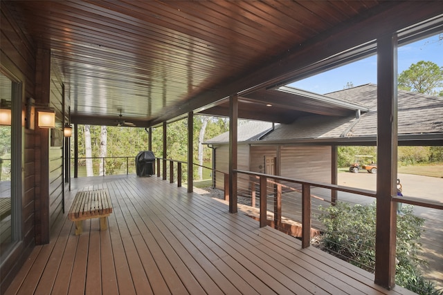 wooden terrace featuring covered porch, grilling area, and ceiling fan