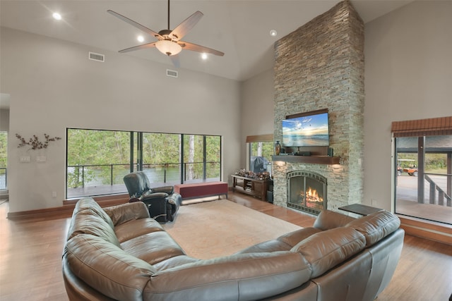 living room with a towering ceiling, a wealth of natural light, and light wood-type flooring