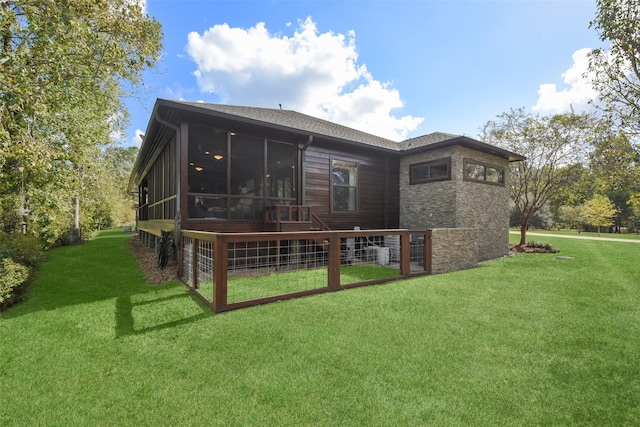 back of property featuring a sunroom and a yard