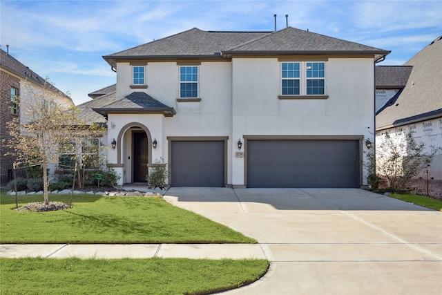 view of front of property featuring a front yard and a garage