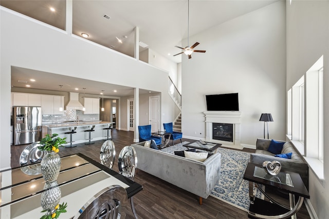 living room with sink, a high ceiling, ceiling fan, and dark hardwood / wood-style flooring