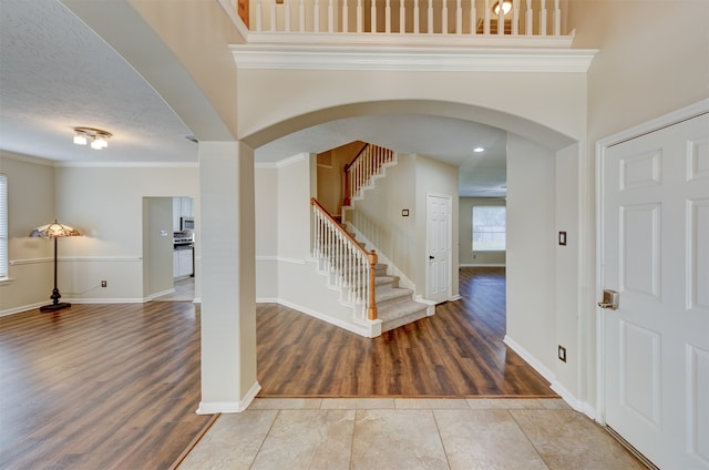 entryway featuring ornamental molding, hardwood / wood-style floors, and a textured ceiling