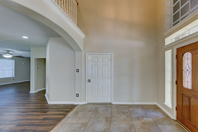 entrance foyer featuring hardwood / wood-style floors, a towering ceiling, and ceiling fan