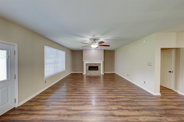 unfurnished living room featuring dark wood-type flooring and ceiling fan