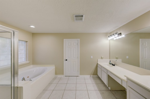 bathroom featuring vanity, a bathtub, a textured ceiling, and tile patterned flooring