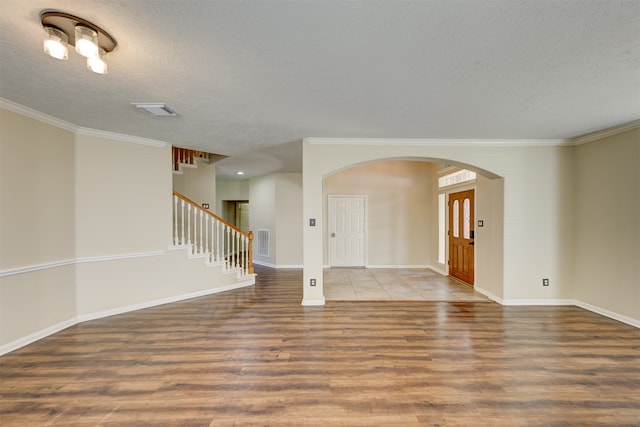 spare room featuring crown molding, a textured ceiling, and hardwood / wood-style floors