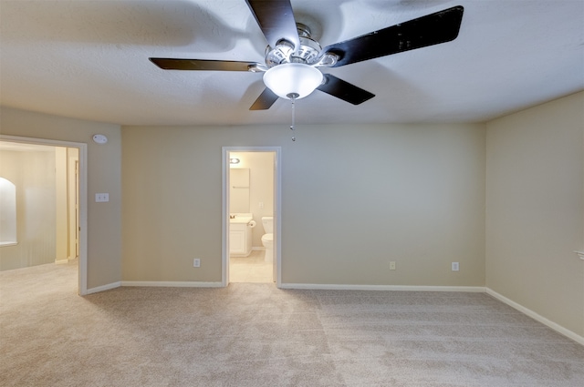 unfurnished bedroom with connected bathroom, ceiling fan, and light carpet