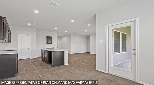 40746 Rosemary Rain, Magnolia, TX 77354 - kitchen with a sink, wood finished floors, recessed lighting, a kitchen island with sink, and dark brown cabinets