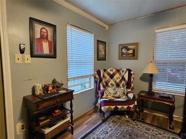 sitting room with ornamental molding and hardwood / wood-style floors