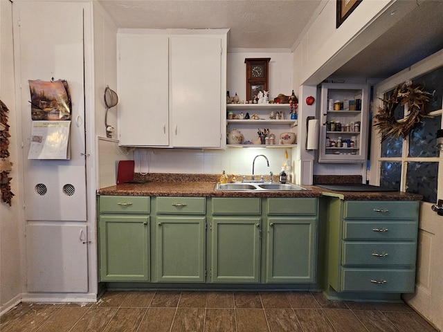 kitchen with decorative backsplash, white cabinetry, sink, and green cabinetry