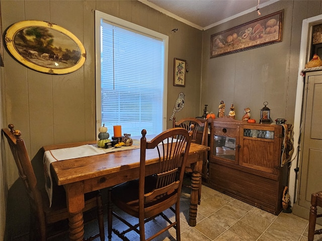 dining area with light tile patterned flooring and crown molding