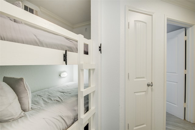 bedroom with light hardwood / wood-style floors and ornamental molding