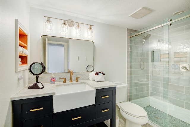 bathroom featuring vanity, toilet, a textured ceiling, and a shower with door