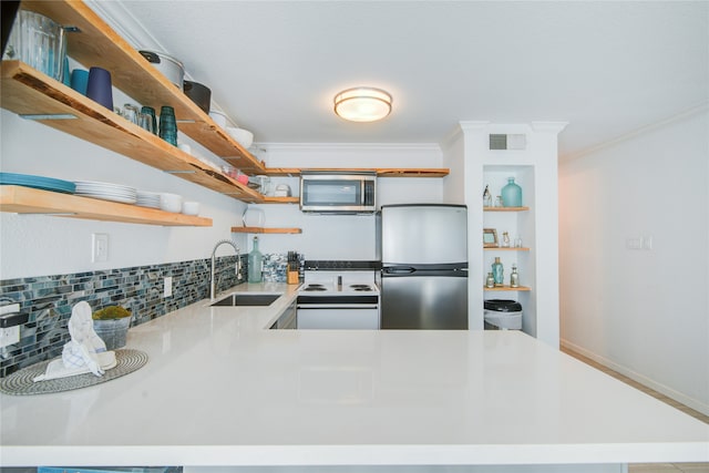 kitchen featuring decorative backsplash, kitchen peninsula, ornamental molding, sink, and appliances with stainless steel finishes