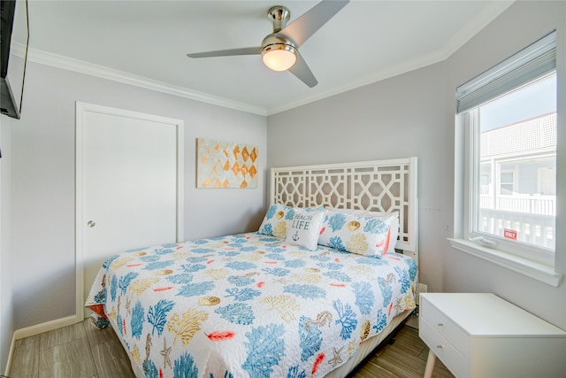 bedroom with dark wood-type flooring, ceiling fan, and ornamental molding