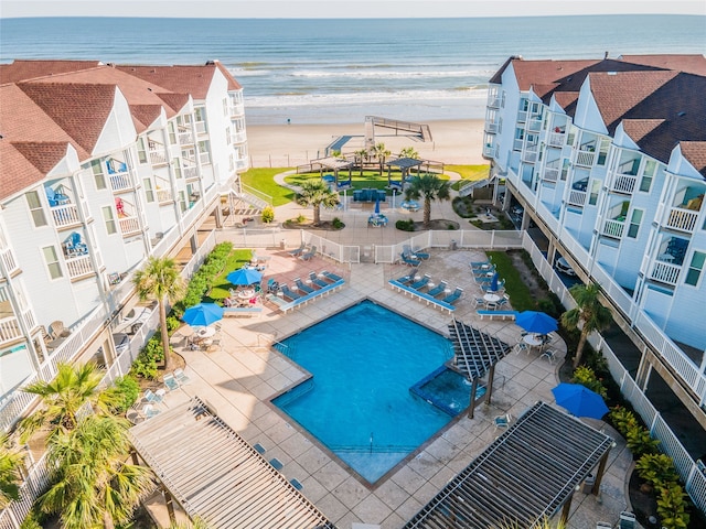 birds eye view of property with a water view and a beach view