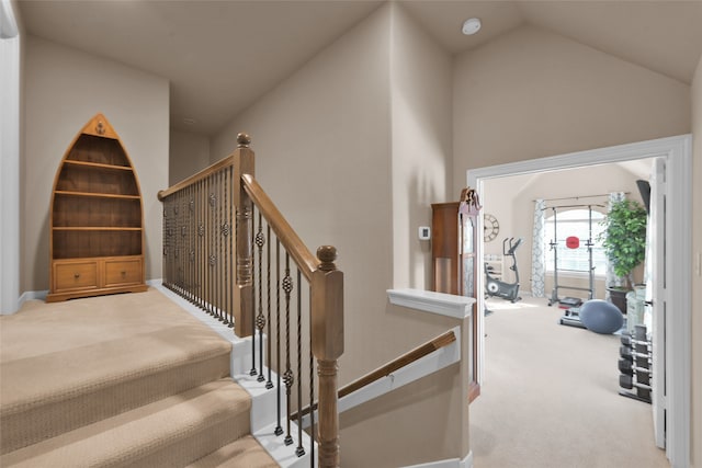 stairway with carpet floors and vaulted ceiling