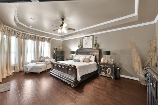 bedroom featuring ceiling fan, a raised ceiling, crown molding, and dark hardwood / wood-style floors