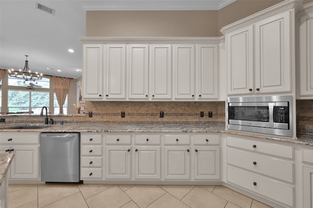 kitchen with ornamental molding, appliances with stainless steel finishes, and white cabinets