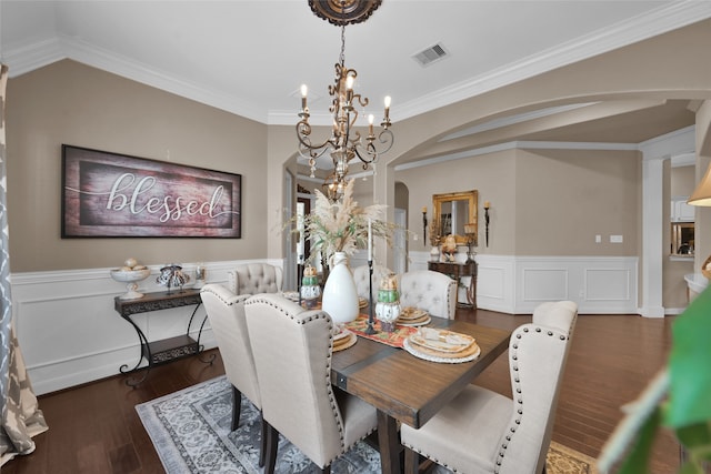 dining area with an inviting chandelier, ornamental molding, and dark hardwood / wood-style flooring