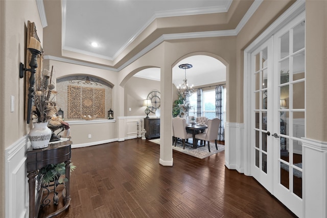 foyer with french doors, crown molding, a chandelier, and dark hardwood / wood-style floors